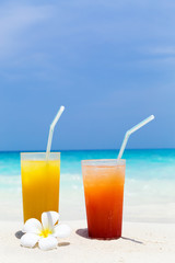 Cocktails in glass on white sandy beach