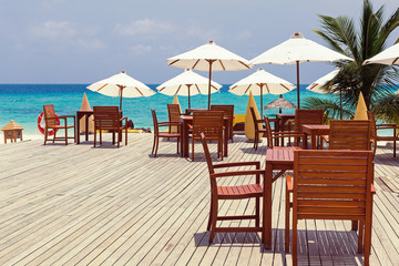 Wooden furniture with tables and chairs on terrace