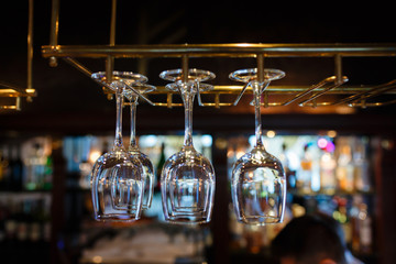 Glasses champagne hangs above the bar counter in the bar. Glasses cocktail hanging glasses over a bar rack.