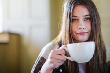 Beautiful brunette drink tea and warm herself