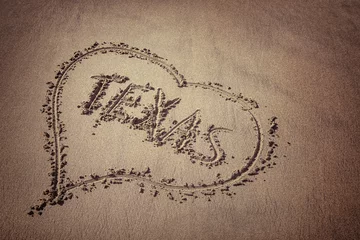 Foto op Canvas The word Texas and heart drawn on the beach sand. Love Texas concept. © leekris