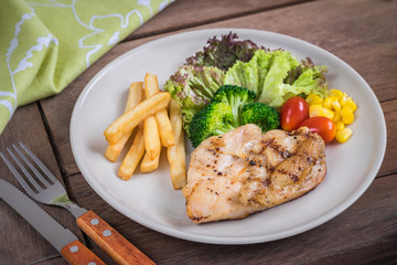 Grilled chicken steak and french fries on plate