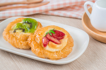 Danish pastry with fruit on plate.
