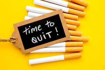 No Smoking - Time to Quit - with cigarettes and handwritten blackboard on yellow background
