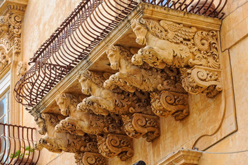 Wrought-iron balcony of the baroque Villadorata Palace in Via Nicolaci supported by five carved winged horses - Noto, Sicily, Italy - obrazy, fototapety, plakaty