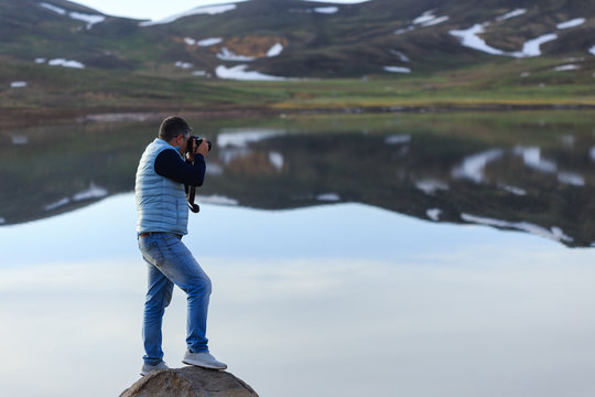 Landscape photographer photographing mountain lake