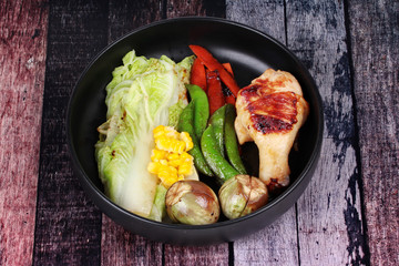 Chicken drumstick steak and grilled mixed vegetables .