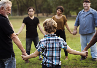 Group of people holding hand together in the park