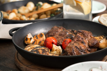 Beef steak grilled in grill pan on wooden table