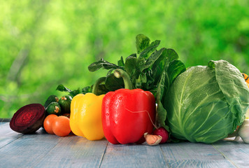 Different raw fresh vegetables оn blue wooden table cloe up