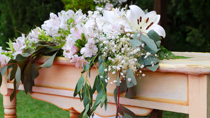 Close up of rustic altar decorated with lilies, alstroemerias and chrysanths. Wedding floral decor concept.