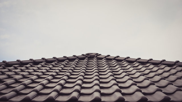 Dark brown ceramic tile roof . Toned image.