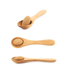 Almond nut in a wooden spoon isolated