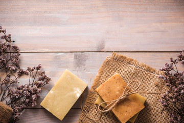 Natural soap with dried flowers on wooden background.