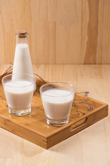 Dairy products. A bottle of milk and glass of milk on a wooden table.