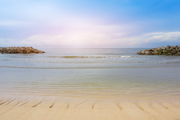 beautiful  beach with rock dam and bright cloudy sky, Thailand