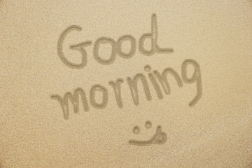 good morning hand writing with smiling face on fine samd