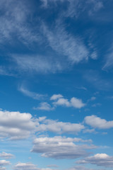 Blue sky with clouds over horizon. White clouds flying against blue sky.