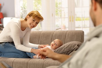 Happy mother and baby looking at father