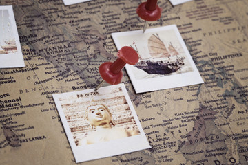Vintage world map and photos pinned on it