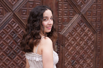 Young girl in front of wooden vintage door