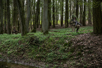 Camouflaged soldiers in forest © Piotr Jankowiak