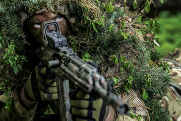 Camouflaged soldiers in forest © Piotr Jankowiak
