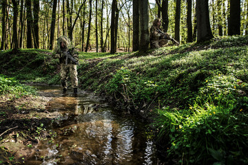 Camouflaged soldiers in forest © Piotr Jankowiak
