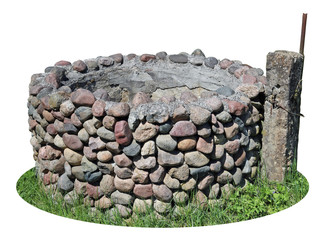 The old destroyed rural well is made of small granite cobble stones