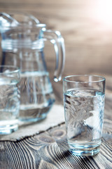 Glass of water on a wooden table.