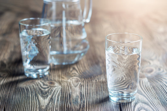 Glass of water on a wooden table.