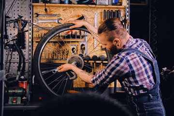 Fototapeta na wymiar Mechanic removing bicycle rear cassette in a workshop.