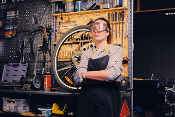 Portrait of female bicycle mechanic over tool stand background.