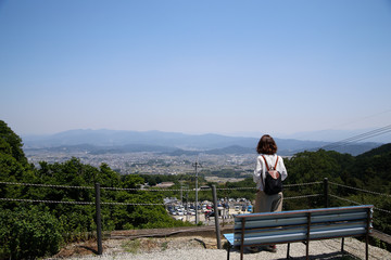 Fototapeta na wymiar 山の上から町を見る女性