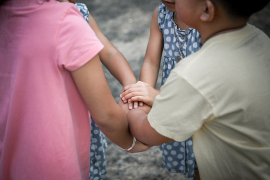 Children holding hand s and playing together in the park in vintage color tone