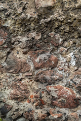 Wallpaper granite stones in cement . Pattern grey red style vintage rough round decorative real stone wall surface with cement.