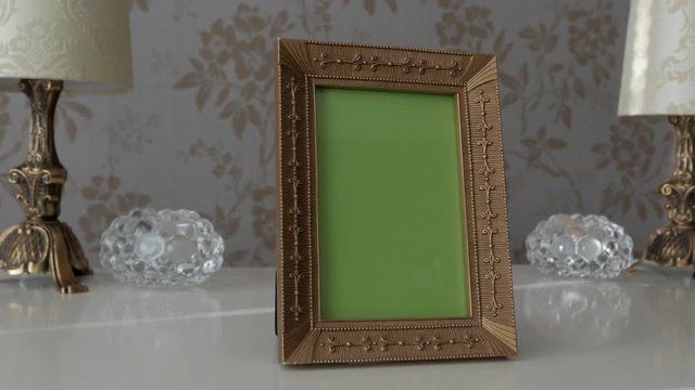 Gold picture frame with green screen on drawer