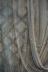 Dark green fishing nets weigh on the fence. Abstract background