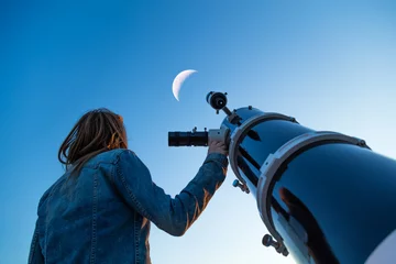 Fototapeten Girl looking at the Moon through a telescope. My astronomy work. © astrosystem
