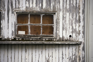 Old window of wooden house painted peeling white paint