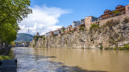 Fototapeta na wymiar Metekhi church and Houses on the edge of a cliff above the river Kura. Tbilisi, the historic city center