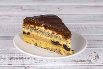 Chocolate piece of cake from biscuit dough with poppy seed, prune and walnuts
