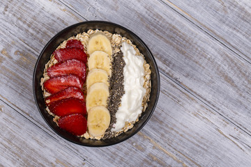 Muesli made from red strawberries, banana, chia seeds, oat flakes, honey and dressed with yogurt