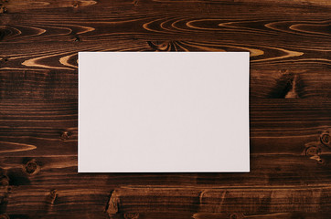 Blank white paper A4, envelope on vintage brown  wooden board. Mock up for branding identity.