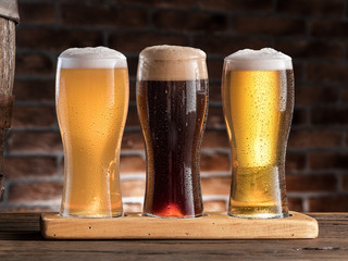 Glasses of beer on the wooden table.