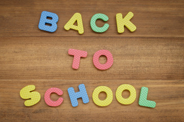 text back to school made from foam alphabet on wooden background