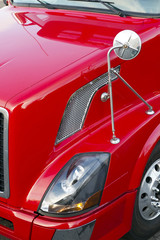 Obraz na płótnie Canvas Red semi truck hood, head light,mirror and wheel