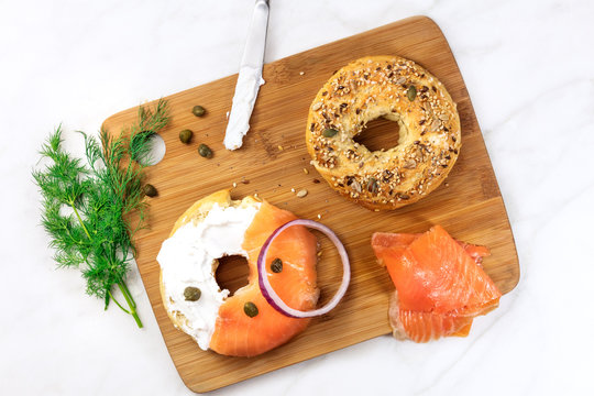Making lox bagels, on white marble background with copyspace