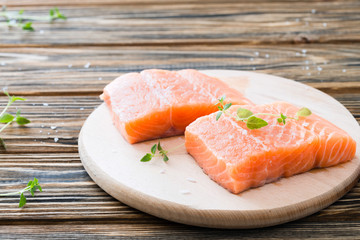 Raw uncooked salmon on cutting board on wooden table