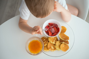 The child has Breakfast on a Sunny morning